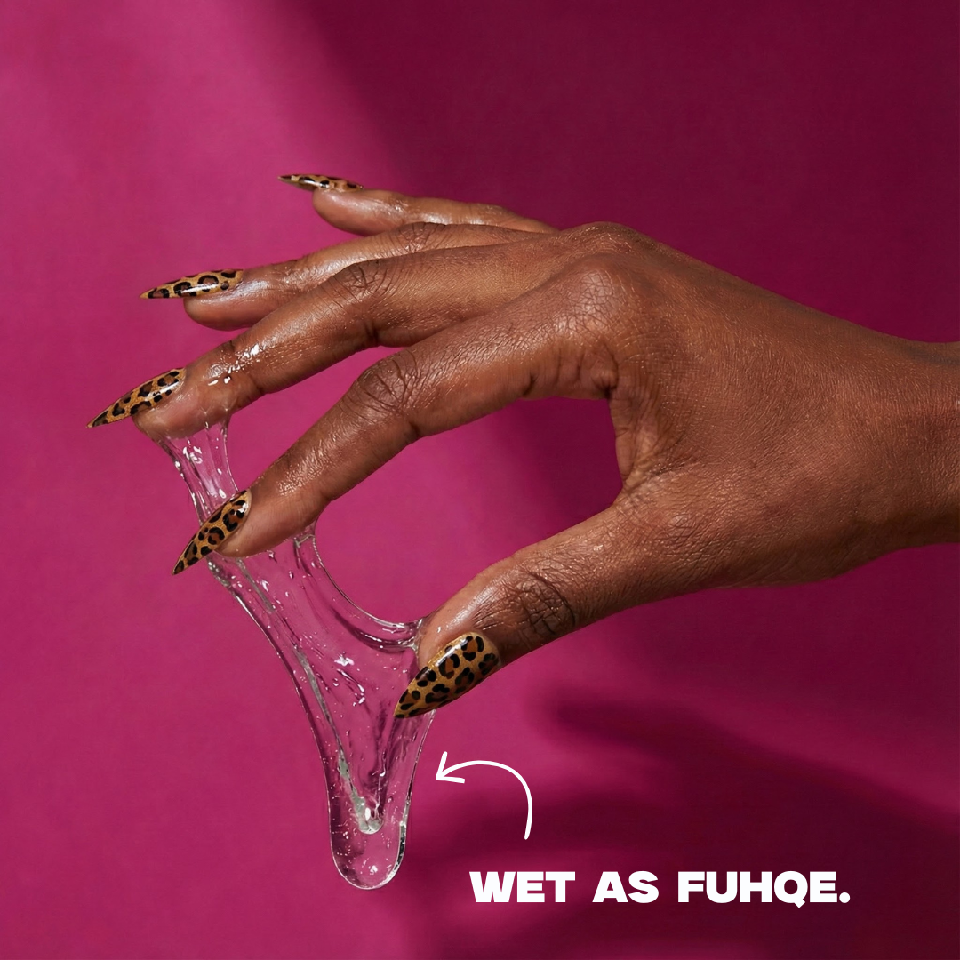 Hand with wet nail polish and text 'WET AS FUHQE' on a pink background