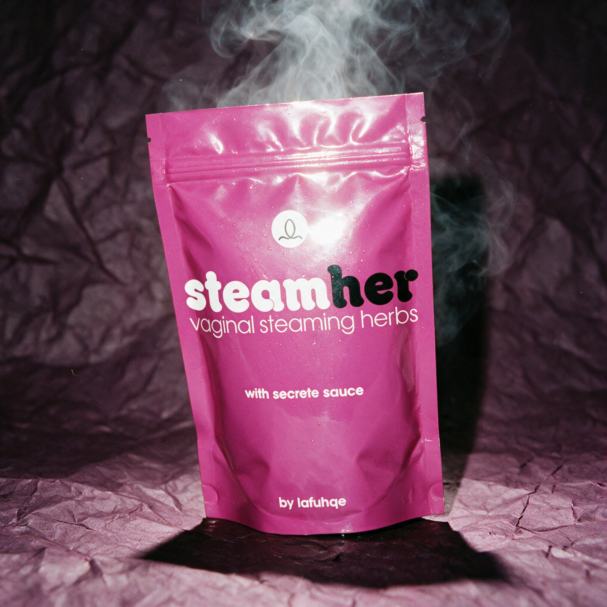 Steam Her vaginal steaming herbs pouch photographed with steam on plum backdrop