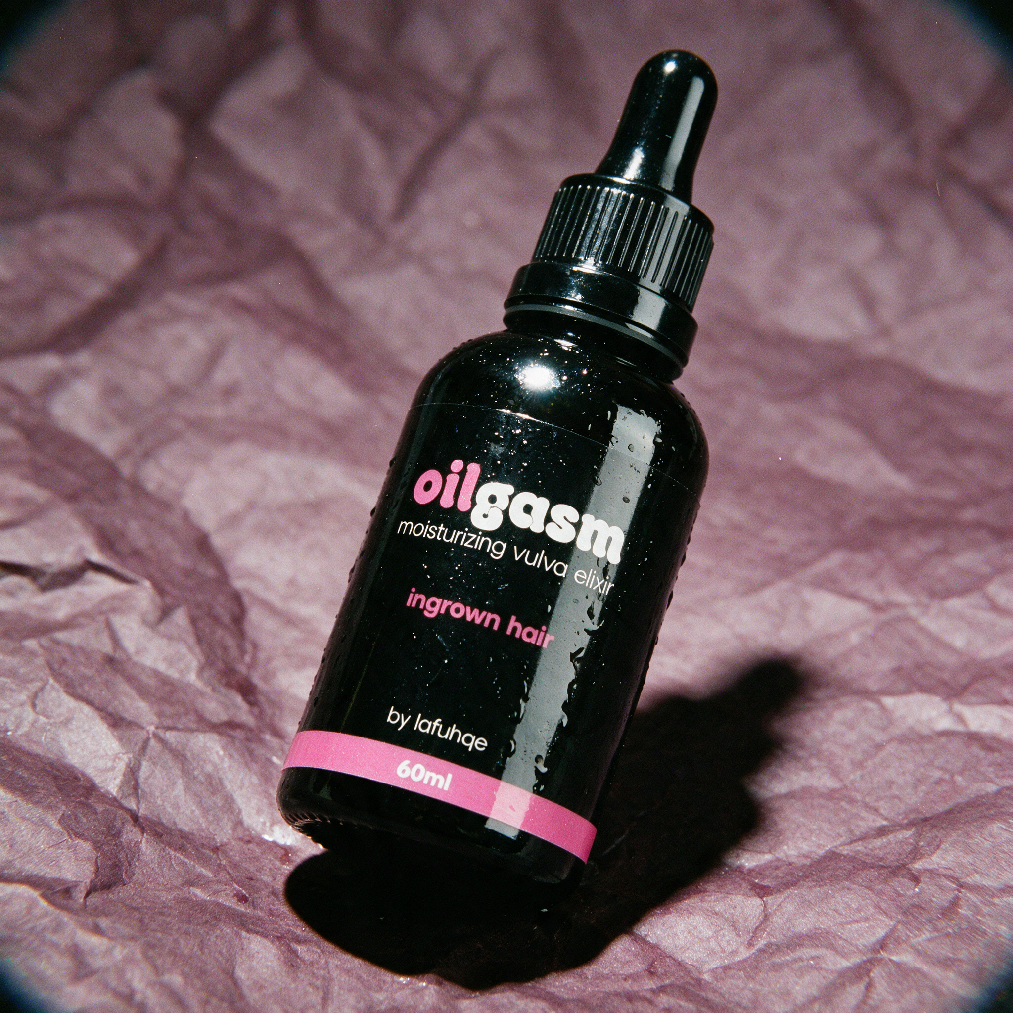 Oilgasm dark spot and ingrown hair eraser photographed on dark mauve plum backdrop