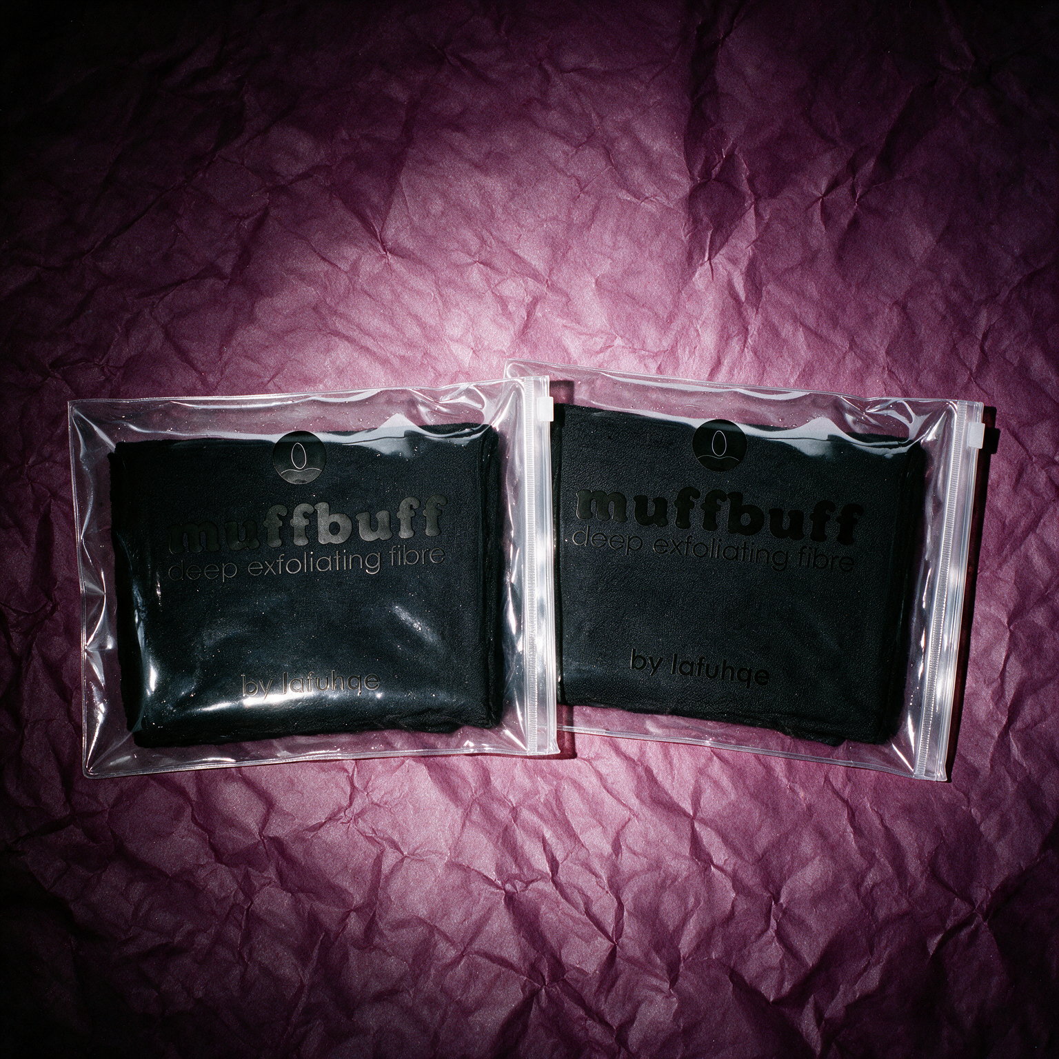 Muff Buff exfoliating kit on deep plum crumpled paper