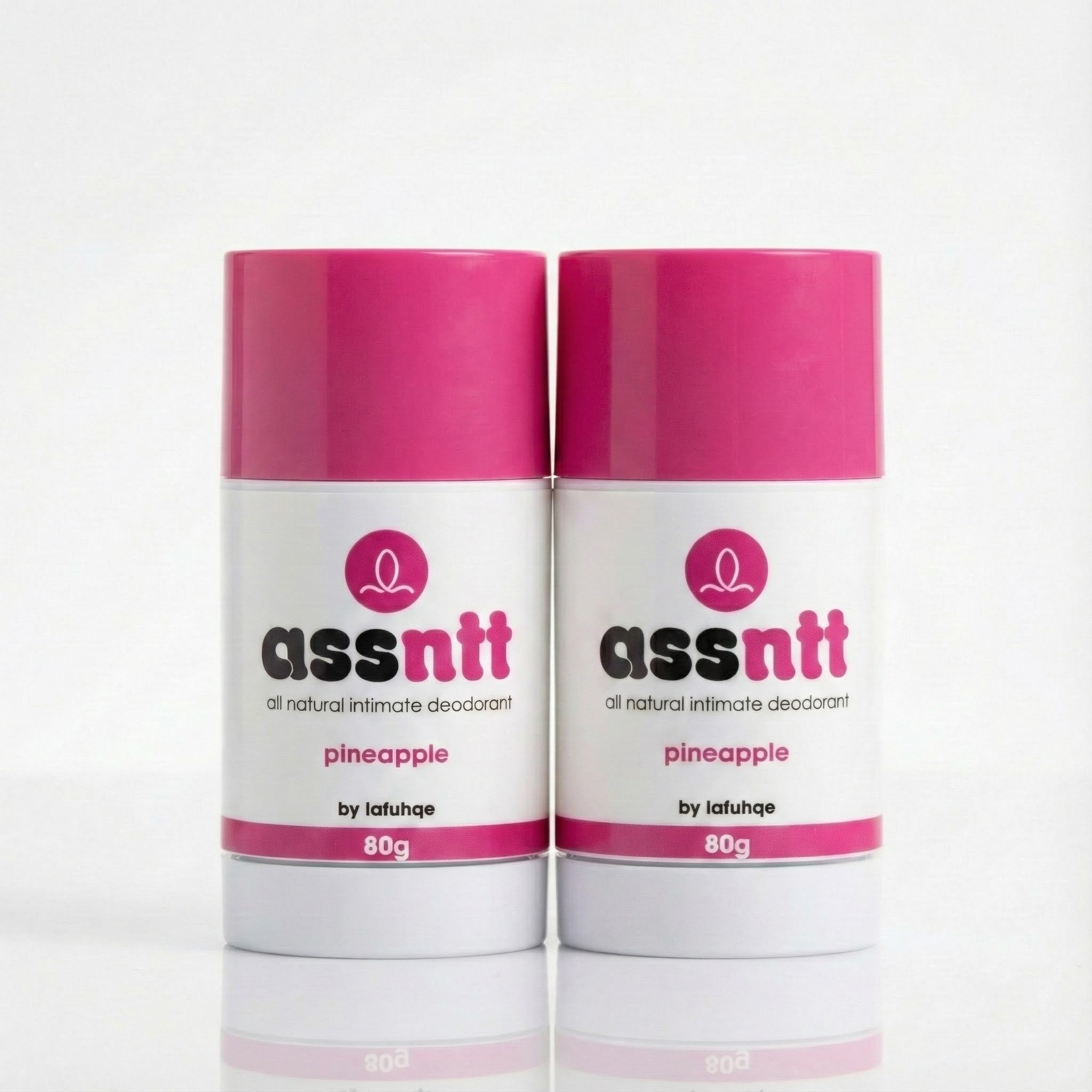 Two containers of 'assnnt' all natural intimate deodorant with pink caps on a white background.
